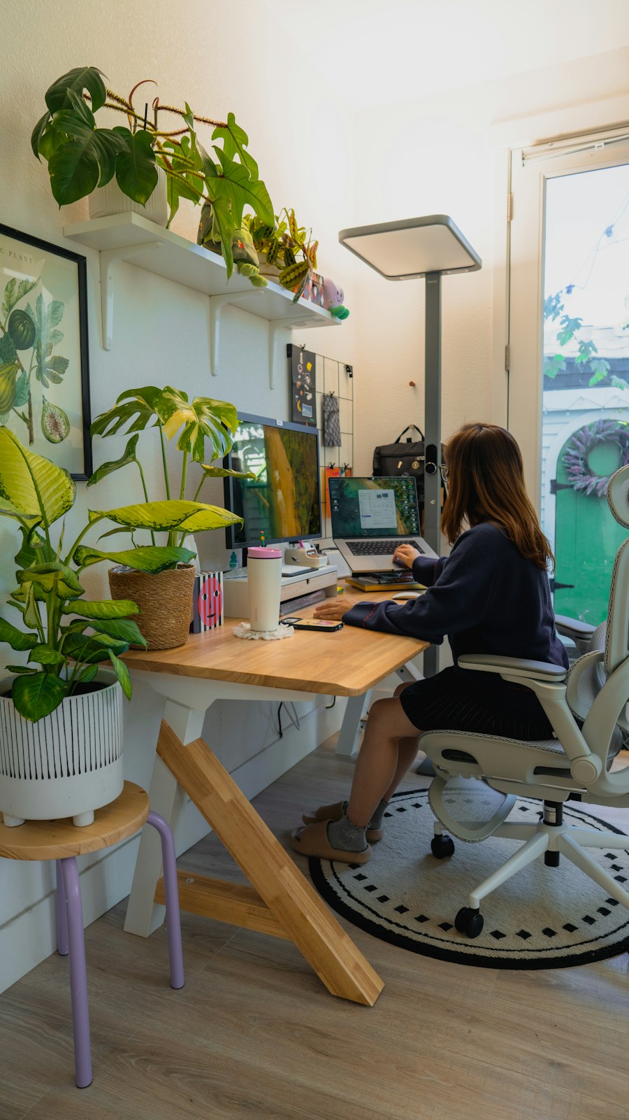 A founder at a wooden desk with plants and soft daylight